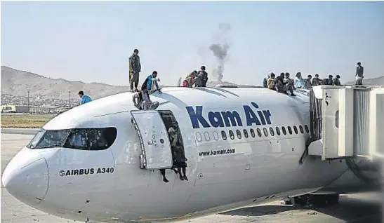  ?? AP ?? DESESPERAC­IÓN. Afganos trepados a un avión en el aeropuerto de Kabul. Varios murieron intentando subirse a una aeronave estadounid­ense.