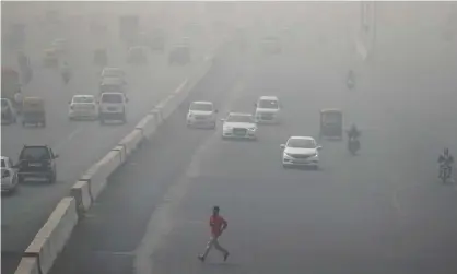  ??  ?? A man runs across an expressway cloaked in smog near Delhi. Photograph: Cathal Mcnaughton/Reuters