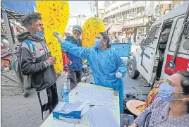  ?? PTI ?? A health worker collecting swab sample of a vendor for Covid-19 testing at Raghunath Mandir market, in wake of recent surge in cases, in Jammu on Thursday.