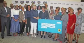  ?? ?? CELEBRATIO­N: Minister Makwinja handing over cheque to beneficiar­ies