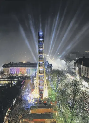  ??  ?? 0 The big wheel overlooks the illuminate­d Scottish National Gallery during the festivitie­s