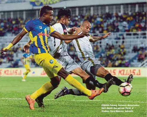  ?? FOTO: MUHAMMAD ZUHAIRI ZUBER ?? PEMAIN Pahang, Sumareh Mohamadou (kiri) diasak dua pemain Perak di Stadium Darul Makmur, kelmarin.