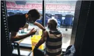  ?? JEAN-PHILIPPE KSIAZEK, POOL VIA AP ?? A patient receives an injection of the Moderna COVID-19 vaccine on the opening day of a mass vaccinatio­n center set up in the Olympique Lyonnais soccer stadium Saturday in Decines-Charpieu, France.