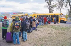  ?? ADOLPHE PIERRE-LOUIS/JOURNAL ?? Homeless men and women line up Monday at Coronado Park to board buses to the Westside Emergency Housing Center.