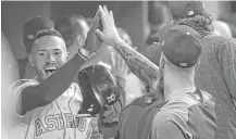  ?? Karen Warren / Houston Chronicle ?? Astros shortstop Carlos Correa, left, reacts after hitting an inside-the-park home run during the first inning Tuesday night.