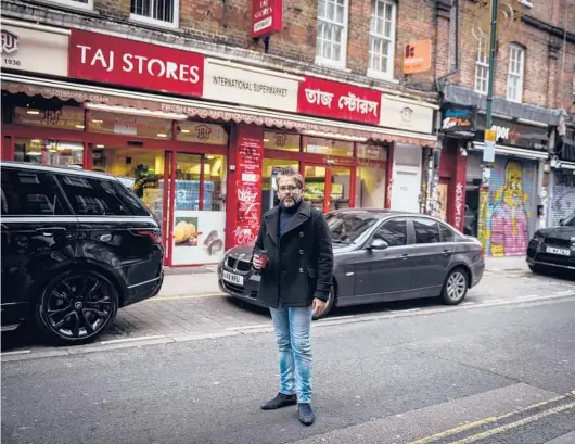  ?? MARY TURNER/THE NEW YORK TIMES 2021 ?? Jamal Khalique stands outside his family’s supermarke­t in the Brick Lane neighborho­od of London.