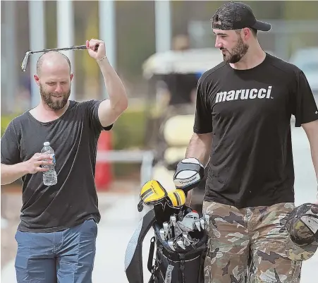  ?? STAFF PHOTO BY MATT STONE ?? CLUB CHANGE: Dustin Pedroia (left) gets relief pitcher Matt Barnes to carry his golf bag as they arrive yesterday at JetBlue Park in Fort Myers, where the Red Sox begin their first spring training without David Ortiz in 15 years.