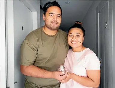  ?? DOMINICO ZAPATA/STUFF ?? Reginald Matekohi and Lotomau Matekohi hold a silver and pink urn with their daughter Angelina’s ashes.