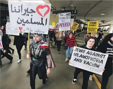  ?? Photograph­s by Luis Sinco Los Angeles Times ?? ABOUT 100 anti-ban demonstrat­ors march at Los Angeles Internatio­nal Airport on Saturday. The protests have come in response to the Jan. 27 order that banned people from seven predominan­tly Muslim nations.