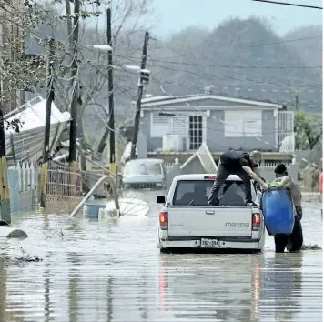  ?? CARLOS GIUSTI/AP PHOTO ?? Residents evacuate after the passing of hurricane Maria, in Toa Baja, Puerto Rico, on Friday.