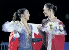  ?? IVAN SEKRETAREV/THE ASSOCIATED PRESS ?? Kaetlyn Osmond, right, and Gabrielle Daleman, both of Canada, smile posing with their silver and bronze medals and the national flag during victory ceremony at the World figure skating championsh­ips in Helsinki, Finland.