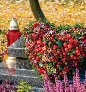  ?? Foto: katarinago­ndova , stock.adobe.com ?? Lilafarben­e Erika eignet sich gut als farbenfroh­e Herbstbepf­lanzung. Ein Gesteck aus saisonalen Blüten und Beeren schmückt das Grab zu Allerheili­gen ganz besonders.