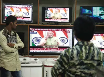  ??  ?? HYDERABAD: People watch Indian Prime Minister Narendra Modi addressing the nation, on television in Hyderabad, India. —AP