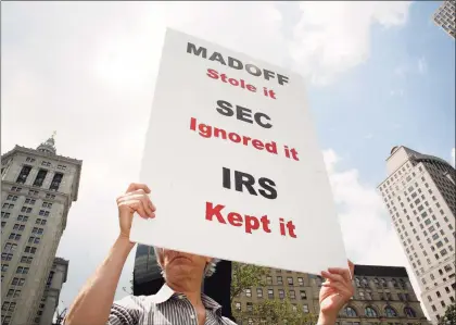  ?? Associated Press ?? A man holding a sign in protest of Bernard Madoff in June 2009, near the courthouse complex where Madoff was sentenced to 150 years for fraud scheme. Until Madoff’s Ponzi scheme came crashing down the SEC esteemed him as a prominent Wall Street figure, failing to heed warnings and credible complaints over 10 years.