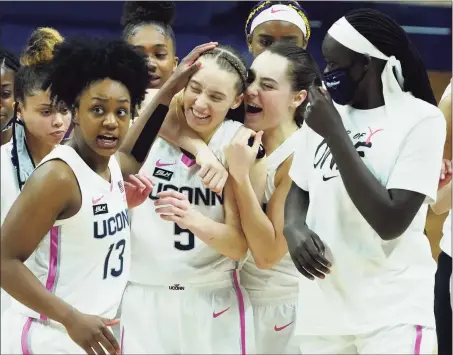  ?? David Butler II / USA Today ?? UConn’s Nika Muhl hugs guard Paige Bueckers (5) after defeating South Carolina in overtime on Monday in Storrs.