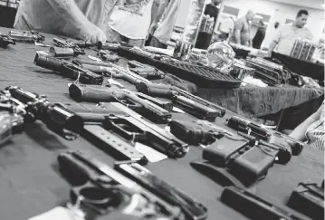  ?? SPENCER PLATT Getty Images/TNS, file ?? Guns stand for sale at a gun show on Nov. 24, 2018, in Naples, Fla. Between 2017 and 2021, federal investigat­ions linked unlicensed dealers to 68,388 trafficked guns and 368 shootings.