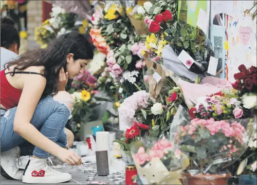  ?? PICTURE: GETTY IMAGES. ?? IN MEMORY: A girl lights a candle at a wall of tributes outside Notting Hill Methodist Church, west London, in memory of the victims of the Grenfell Tower block fire.