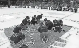  ?? ERIN WOODIEL/AP ?? Teachers scramble for dollar bills between periods of a junior hockey league game in Sioux Falls, S.D., on Saturday.