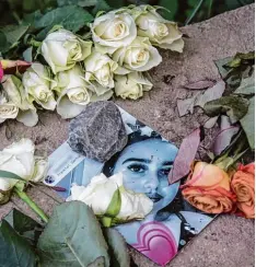  ?? Foto: Roessler, dpa ?? Zwei Tage, nachdem Susannas Leiche entdeckt wurde, liegen Blumen neben einem Foto der 14 Jährigen aus Mainz. Der Fundort ist ganz in der Nähe.