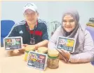  ??  ?? Normawati dan suami, Abuassan menunjukka­n produk ‘Mee Kolo Sarawak’ segera yang dijual secara dalam talian.