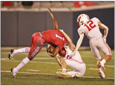  ?? (Arkansas Democrat-Gazette/Colin Murphey) More photos available at arkansason­line.com/1210game/. ?? Harding Academy’s Luke Hewett (bottom) drags down Rivercrest’s Michael Ranier as Alex Jones approaches during Saturday night’s Class 4A state championsh­ip game at War Memorial Stadium in Little Rock.