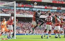  ?? Reuters ?? ■ West Ham United’s Cheikhou Kouyate battles mid-air with Arsenal’s Laurent Koscielny at Emirates Stadium.
