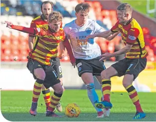  ??  ?? Ayr United’s goal machine, Lawrence Shankland, holds off Partick Thistle’s Blair Spittal, right, and Craig Slater