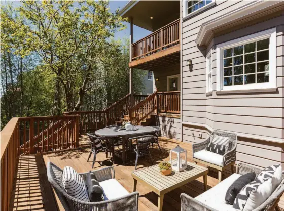  ?? LIZ_RUSBY ?? Above: Both levels of the Piedmont home enjoy view decks. Below left: The primary suite includes a fireplace, sitting area and access to a private deck. Below center: A carpeted family room off the kitchen boasts floor-to-ceiling built-ins. Below right: The carpeted family room includes a built-in desk and access to a rear deck.