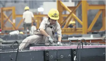  ??  ?? A person works on a steel mesh for an interior part of a precast concrete panel at Broad Homes Industrial Company in Changsha City, central China. China’s economy grew 6.7 percent in the third quarter of 2016, according to the National Bureau of...