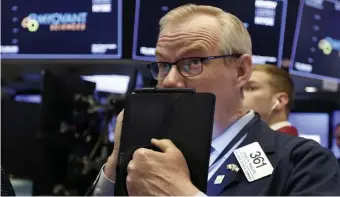  ?? AP ?? VOLATILE MARKET: Trader Dennis Maguire works on the floor of the New York Stock Exchange on Thursday.