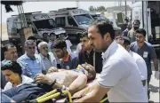  ?? YASIN AKGUL/ ASSOCIATED PRESS ?? Medics carry a wounded man who arrived from the Syrian town of Kobani into a hospital on the Turkish side of the border in Suruc, Turkey, following attacks by Islamic State militants on Saturday.