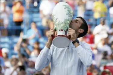  ?? JOHN MINCHILLO — THE ASSOCIATED PRESS ?? Novak Djokovic kisses the Rookwood Cup after defeating Roger Federer during the finals at the Western &amp; Southern Open on Aug. 19.