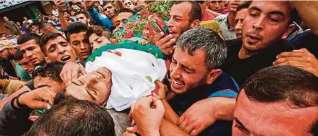  ?? [AFP] ?? Warga Palestin mengusung jenazah Ahmed Abu Lebda, 22, untuk pengebumia­n di Khan Yunis, semalam.