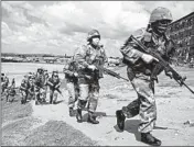  ?? THEMBA HADEBE/AP ?? South African National Defence Forces take up positions Saturday in a township east of Johannesbu­rg, South Africa.