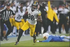  ?? The Associated Press ?? RUNNING TO SCORE: Pittsburgh Steelers running back James Conner, left, gets by Los Angeles Chargers outside linebacker Jatavis Brown as he runs for a touchdown during the first half of Sunday’s game in Carson, Calif.