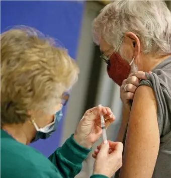  ?? MATT STONE / HErAlD STAFF FilE ?? ANOTHER J&J RECIPIENT: Registered nurse Carrie MacDonald gives Alexander Walsh of Chatham a Johnson & Johnson COVID-19 vaccine at Cape Cod Community College in Barnstable on March 9.