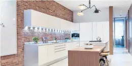  ?? SCOTT GABRIEL MORRIS ?? A modern kitchen is created by incorporat­ing exposed brick as a backsplash in this industrial space.