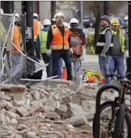  ?? RICK BOWMER — THE ASSOCIATED PRESS ?? Constructi­on workers look at the rubble from a building after an earthquake Wednesday in Salt Lake City.