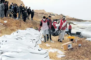  ?? GETTY IMAGES ?? Libyan Red Crescent volunteers recovering the bodies of 74 migrants that washed ashore near Zawiyah on Libya’s northern coast. The Internatio­nal Organizati­on for Migration says another 12 are missing and are presumed dead.