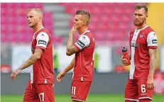  ?? FOTO: ANSPACH/DPA ?? Die FCK-Profis Christoph Hemlein, Florian Pick und Jan Löhmannsrö­ben (von links) sind bedient und verlassen das Spielfeld.