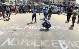  ?? PHOTO: REUTERS ?? A demonstrat­or paints ‘‘End Sars’’, referring to the Special AntiRobber­y Squad police unit, on a street during a protest demanding police reform in Lagos.