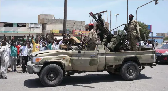  ?? AFP ?? A crowd welcomes Sudanese soldiers loyal to military chief Gen Abdel Fattah Al Burhan as they enter Port Sudan yesterday amid deadly violence in the country