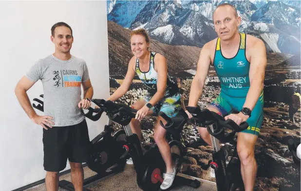  ?? Picture: STEWART McLEAN ?? ON THE UP: Exercise physiologi­st Scott Payne in Cairns Altitude Training room with triathlete­s Shelley Peden and Leigh Whitney on stationary bikes.