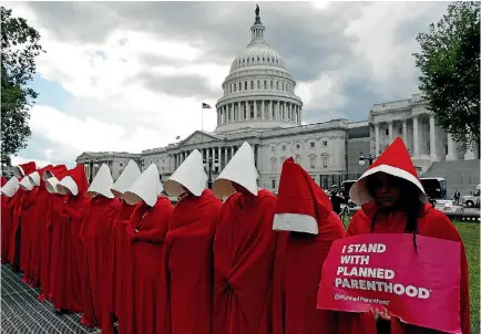  ?? PHOTO: REUTERS ?? Women dressed as handmaids from the novel, film and TV series The Handmaid’s Tale protest against funding cuts for Planned Parenthood in the Republican Senate healthcare bill, at the US Capitol in Washington, DC yesterday.