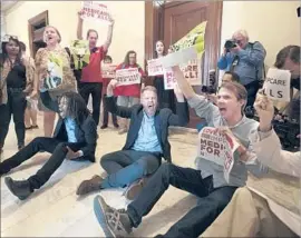  ?? Michael Reynolds European Pressphoto Agency ?? PROTESTERS denounce the GOP healthcare bill at Sen. Ted Cruz’s office.