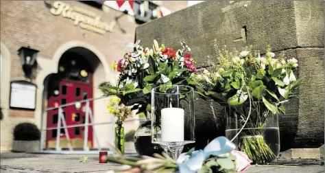  ?? DPA-BILD: KUSCH ?? Blumen liegen an einer Kerze vor dem Restaurant „Kiepenkerl“in der Altstadt von Münster.