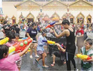  ??  ?? People enjoying themselves during the water festival at Wat Chayamangk­alaram in Pulau Tikus, Penang, yesterday.