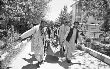  ??  ?? A file photo of Afghan volunteers carrying the body of a resident killed in a car bomb attack to the Wazir Akbar Khan hospital in Kabul. Civilian deaths in Afghanista­n hit a record high in the first half of 2017, with 1,663 killed and more than 3,500...