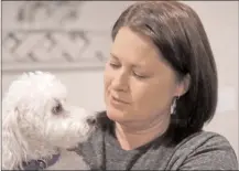  ?? The Associated Press ?? Las Vegas shooting survivor Chris Gilman holds her dog Toby and talks about the comfort he brings her in her recovery at her home in Bonney Lake, Wash.