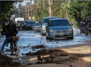  ?? AP file photo ?? Vehicles travel through surf that washed over a roadway in Haleiwa, a Hawaiian city on the north shore of Oahu, earlier this year.